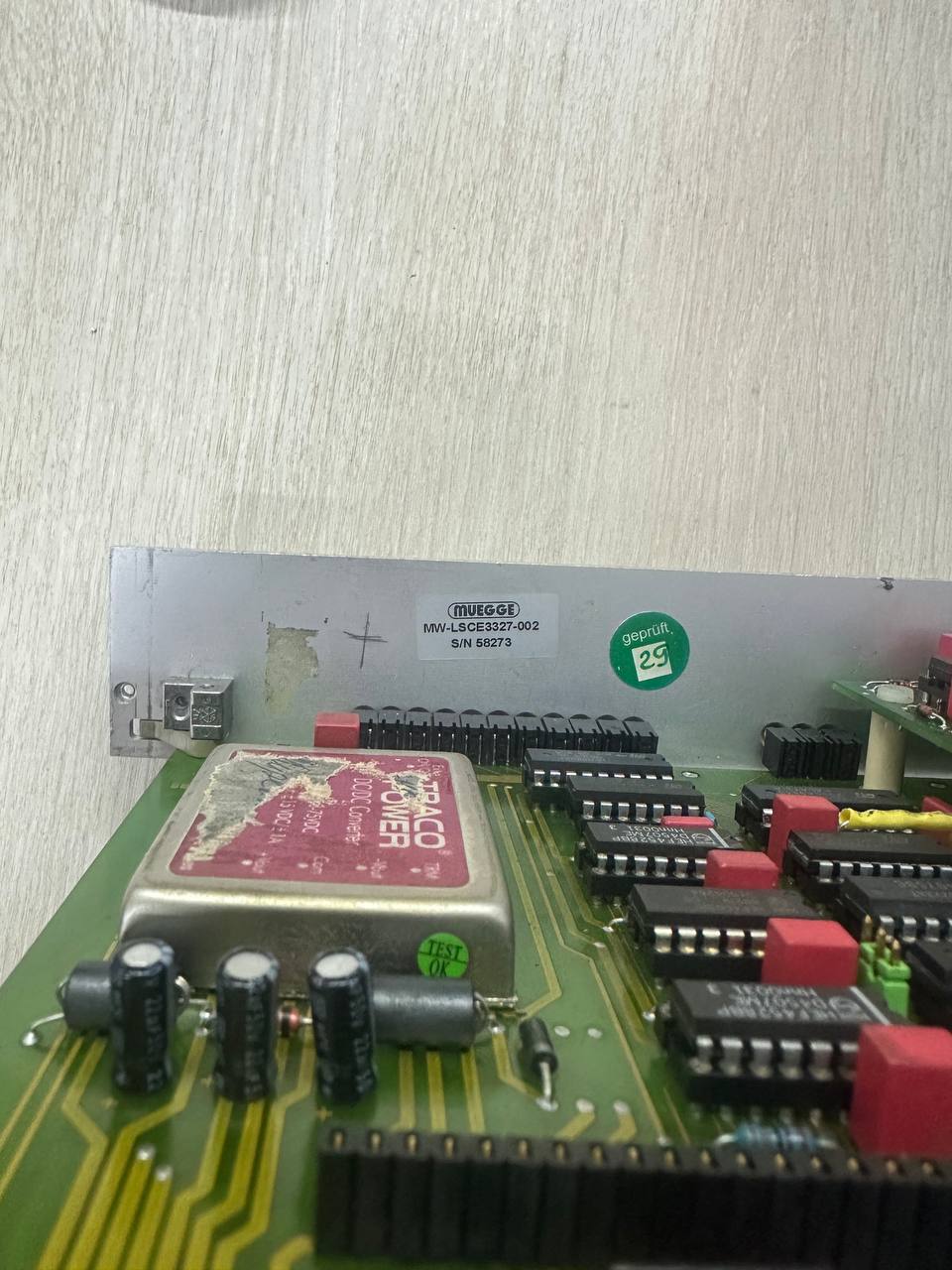 Крупный план заводской маркировки Muegge MW-LSCE3327 на печатной плате промышленного оборудования. Видны установленные преобразователи напряжения Traco Power и интегральные микросхемы, подготовленные к сервисной диагностике.